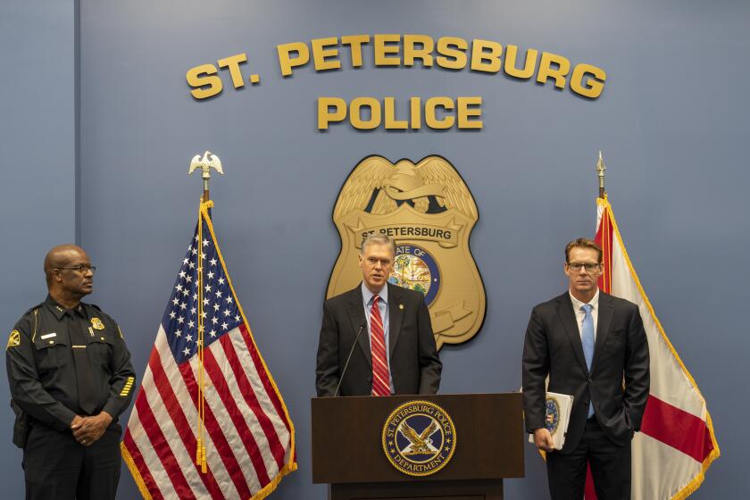U.S. Attorney Roger B. Handberg, alongside St. Petersburg Police Chief Anthony Holloway, left, and FBI Special Agent David Walker, speaks to reporters at St. Petersburg Police Department headquarters, Friday, July 29, 2022, in St. Petersburg, Fla. Aleksandr Viktorovich Ionov, a Russian operative under the supervision of one of the Kremlin's main intelligence services has been charged with recruiting political groups in the United States to advance pro-Russia propaganda, including during the invasion of Ukraine, the Justice Department said. In this case, the authorities say, Ionov from 2014 through last March recruited political groups in Florida, Georgia and California and directed them to spread pro-Russia talking points. (Martha Asencio-Rhine/Tampa Bay Times via AP)