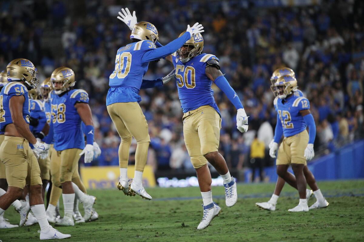 UCLA defensive back Elisha Guidry, left, and defensive lineman Tyler Manoa celebrate a stop.