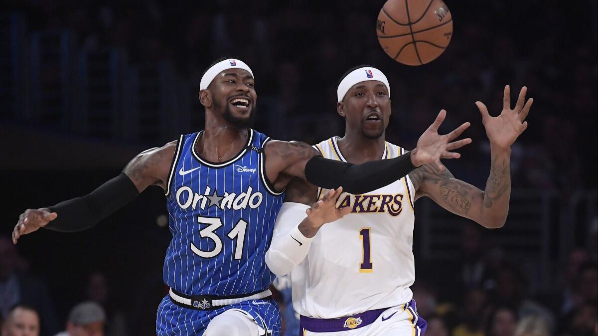 Orlando Magic guard Terrence Ross, left, and Lakers guard Kentavious Caldwell-Pope reach for a loose ball during the first half on Sunday.