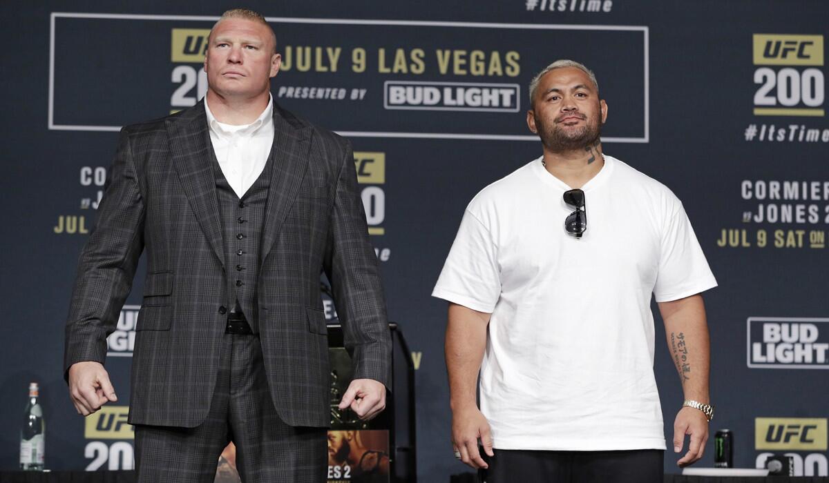 Brock Lesnar, left, and Mark Hunt pose for photographers during a UFC 200 news conference on Wednesday in Las Vegas.