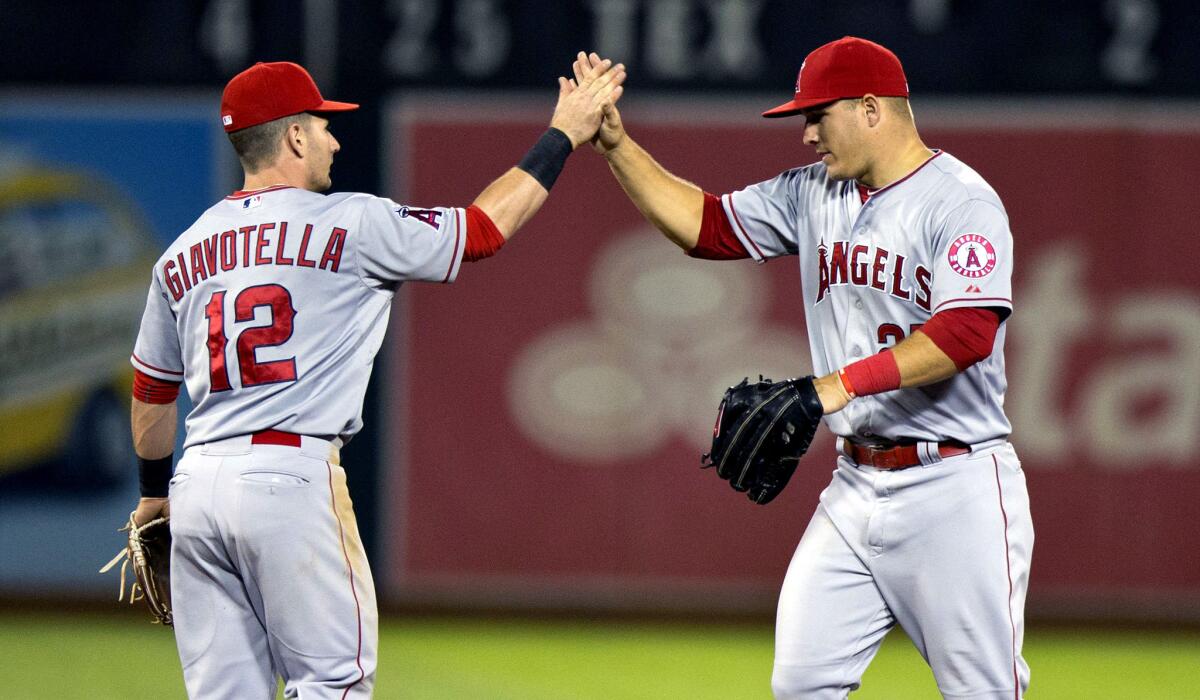 Angels second baseman Johnny Giavotella (12) and center fielder Mike Trout celebrate after a 6-3 victory over the Athletics in Oakland on April 29.