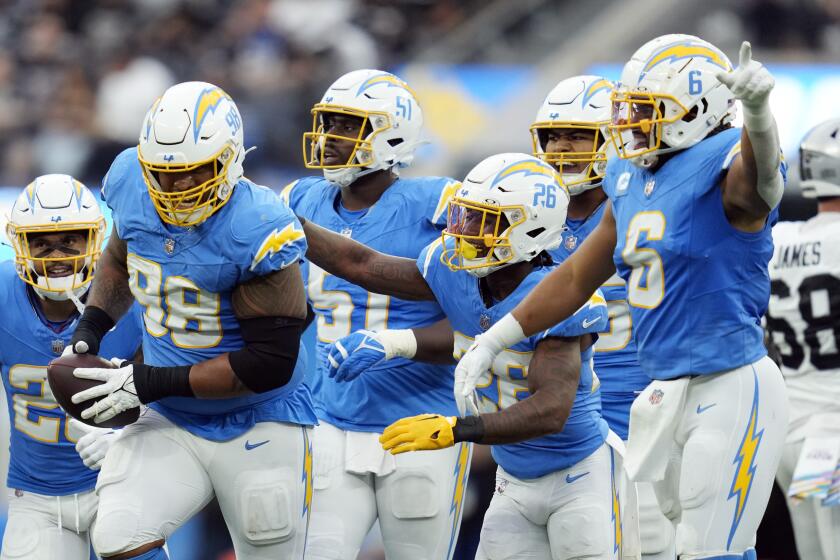 The Los Angeles Chargers celebrate a fumble recovery by defensive tackle Austin Johnson (98) during the first half of an NFL football game against the Las Vegas Raiders Sunday, Oct. 1, 2023, in Inglewood, Calif. (AP Photo/Ashley Landis)