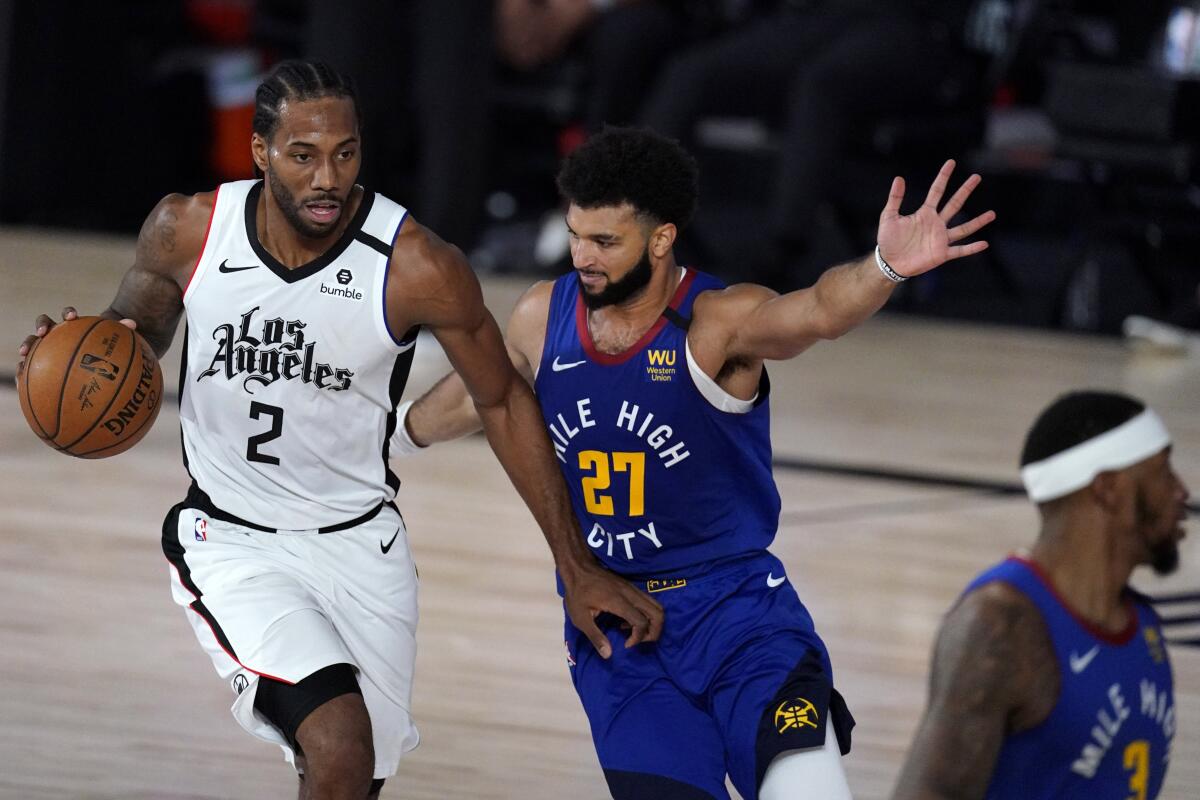 Clippers forward Kawhi Leonard drives against Nuggets guard Jamal Murray during Game 5 on Sept. 11, 2020.