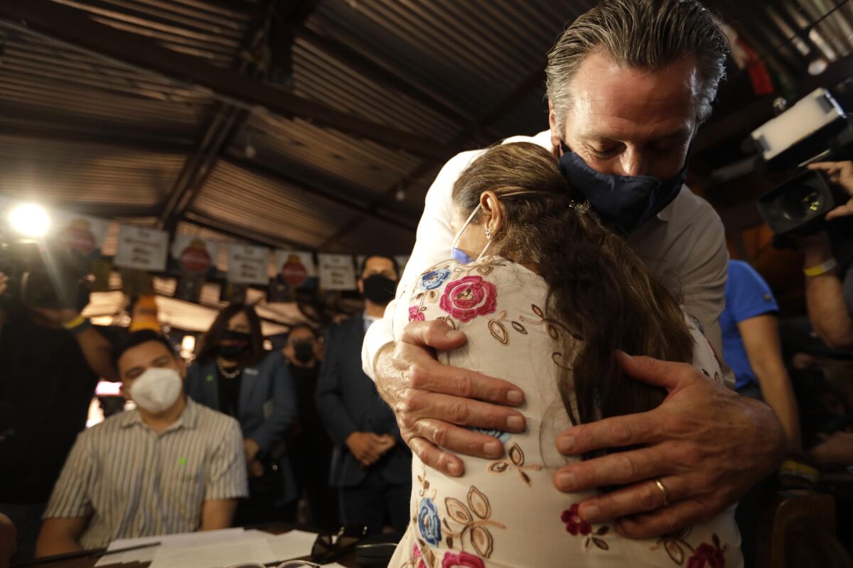 California Gov. Gavin Newsom gives a hug to a volunteer who works the phone banks.