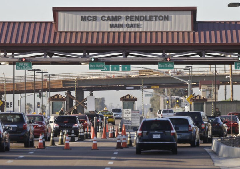 Vehicles file through the main gate of Camp Pendleton Marine Base. Four Marines were killed in an accident on the base.