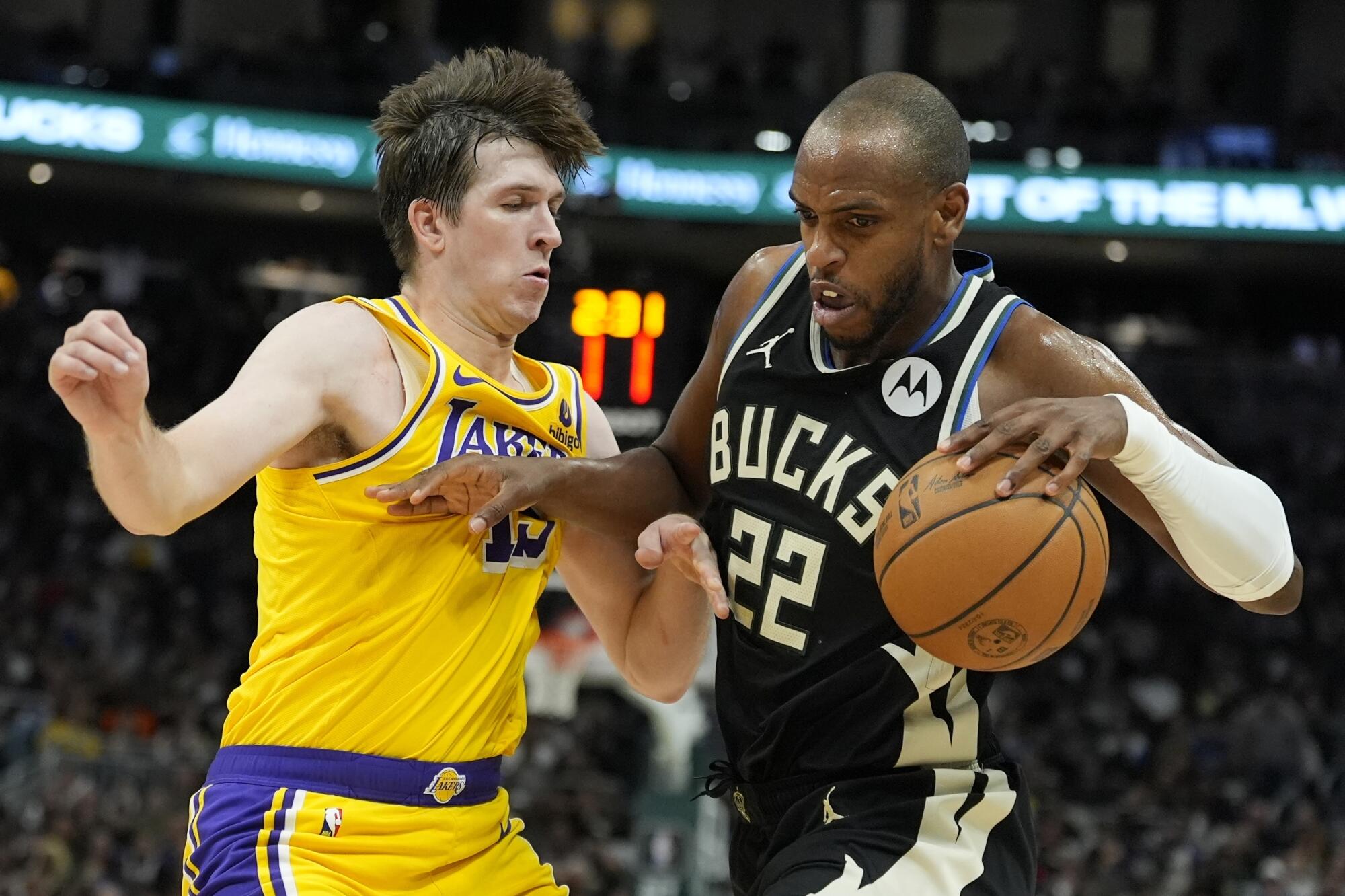 Bucks'tan Khris Middleton Salı günü Milwaukee'de Lakers'ın Austin Reaves'ini geçmeye çalışıyor. 