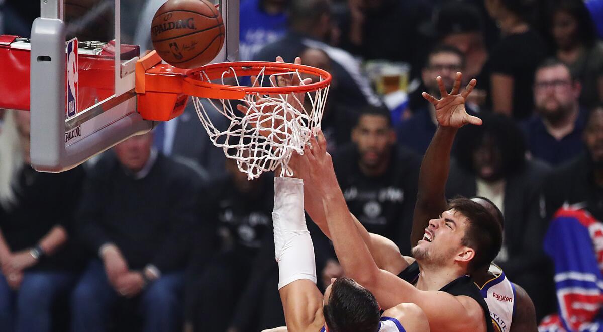 Clippers center Ivica Zubac is fouled on a shot by Warriors center Andrew Bogut during the first half of Game 3.