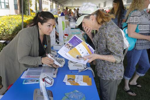 SAN DIEGO, CA 6/9/2018: Sandra Lambarri-Johnson, left, an outreach specialist with the California Telephone Access Program discusses different phones with Felicia Roberto, right, of El Cajon, during the CaregiverSD Community Expo at Liberty Station. Felicia recently became the caregiver for her husband. Photo by Howard Lipin/San Diego Union-Tribune/Mandatory Credit: HOWARD LIPIN SAN DIEGO UNION-TRIBUNE/ZUMA PRESS