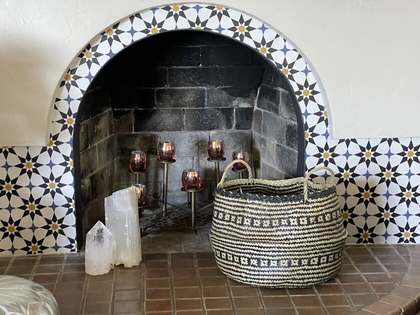 For a quick, low-cost change to her own fireplace, designer Kim Nadel used a temporary wallpaper that looks like tile.