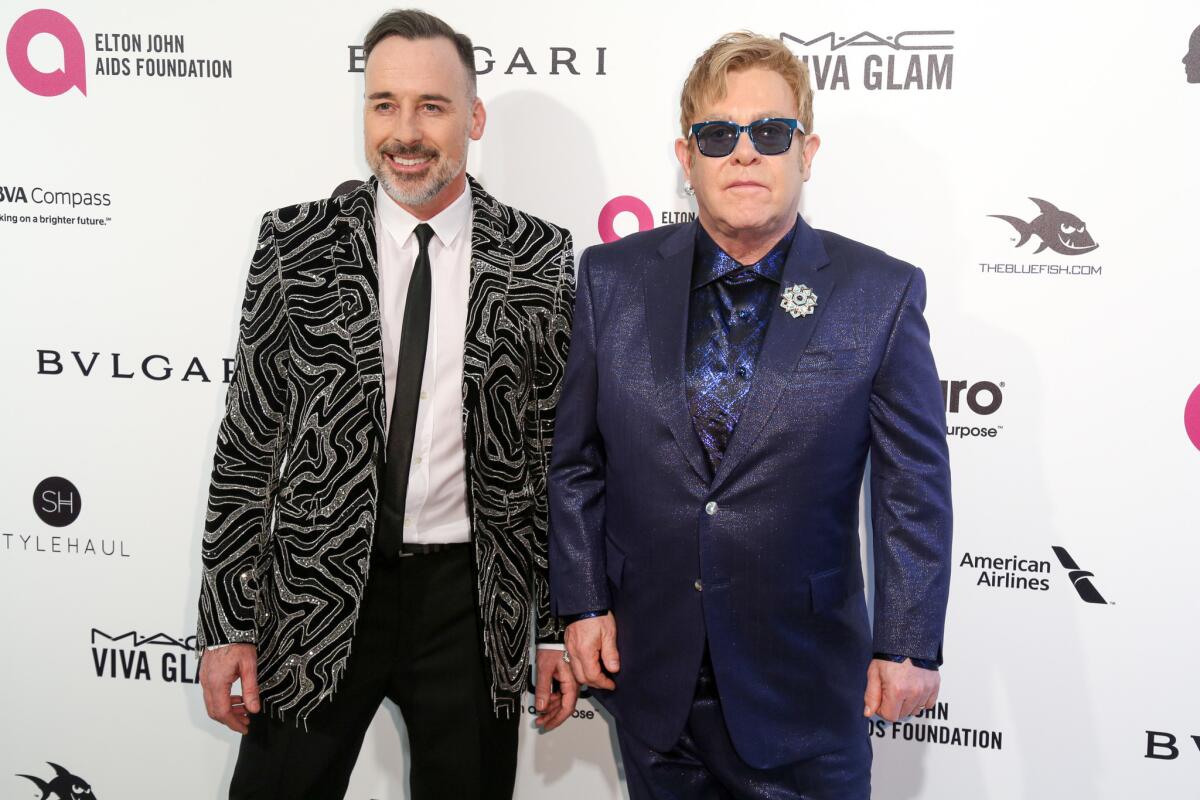 David Furnish, left, and Elton John arrive at the 2016 Elton John AIDS Foundation Oscar viewing party at West Hollywood Park on Sunday in West Hollywood.