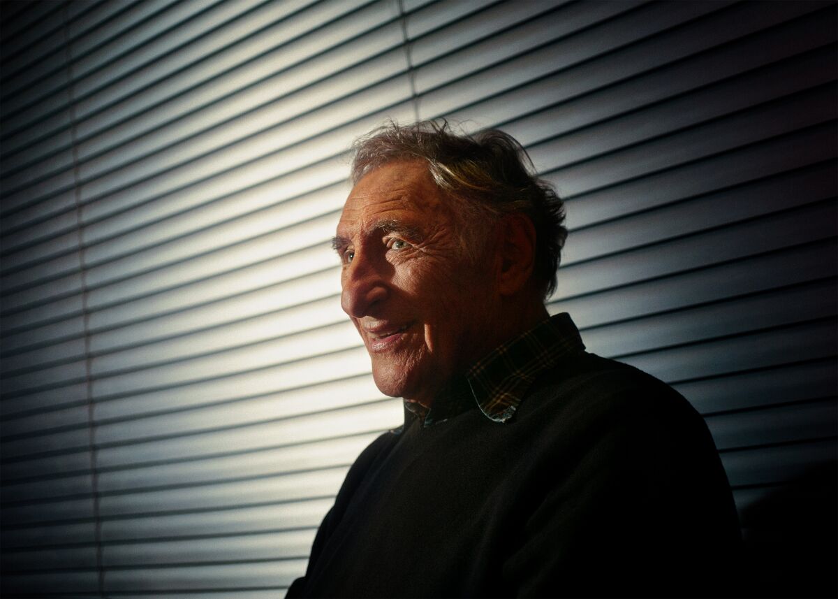 Judd Hirsch stands in front of window blinds for a portrait.
