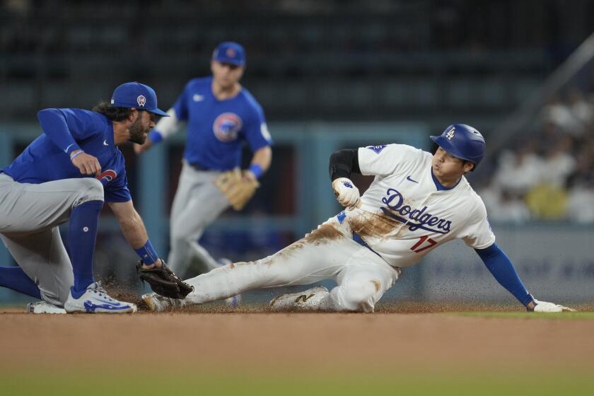 El japonés Shohei Ohtani, bateador designado de los Dodgers de Los ?ngeles, se roba la intermedia ante Dansby Swanson, de los Cachorros de Chicago, el miércoles 11 de septiembre de 2024 (AP Foto/Ashley Landis)