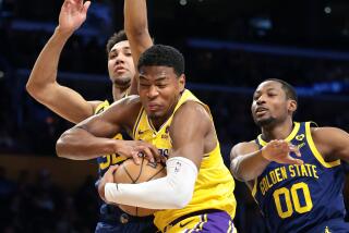 LOS ANGELES, CALIFORNIA - APRIL 9: Lakers Rui Hachimura grabs a rebound from Warriors Trayce Jackson-Davis, left, and Jonathan Kuminga in the second quarter at Crypto.com Arena Tuesday. (Wally Skalij/Los Angeles Times)