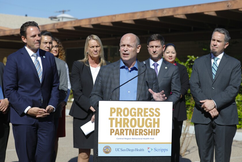 Tom Gammiere, a Scripps Health executive, supports creation of a joint mental health hub on Third Avenue in San Diego during a news conference in October, 2019. Also present are Patty Maysent, chief executive of UC San Diego Health, county supervisor Nathan Fletcher and San Diego city councilman Chris Ward.