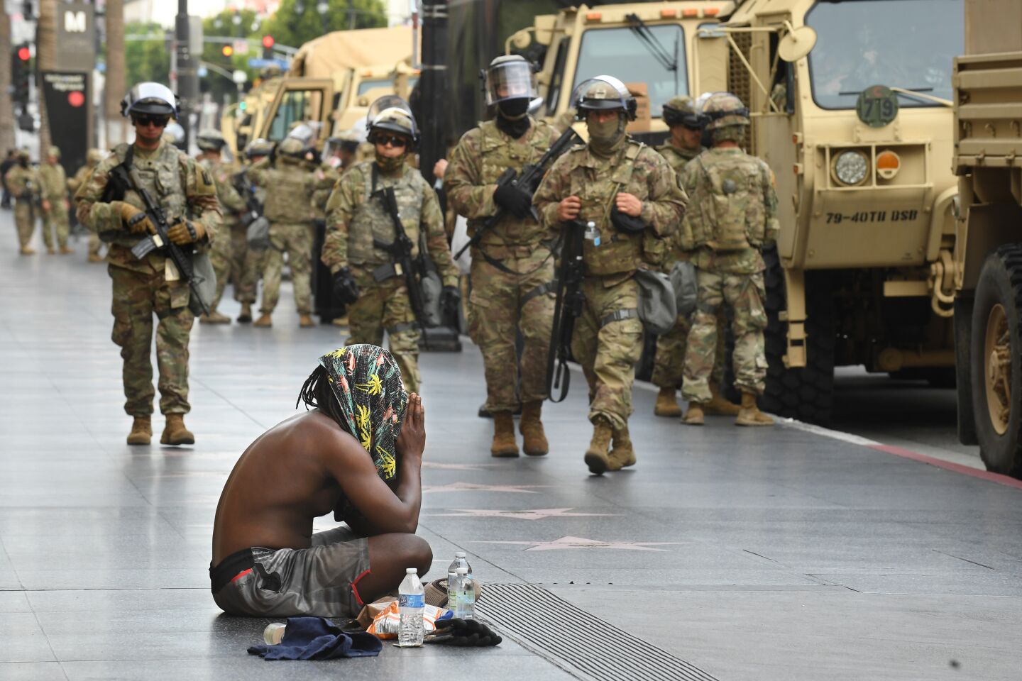 Bando Kev prays along Hollywood Blvd. in front of the National Guard