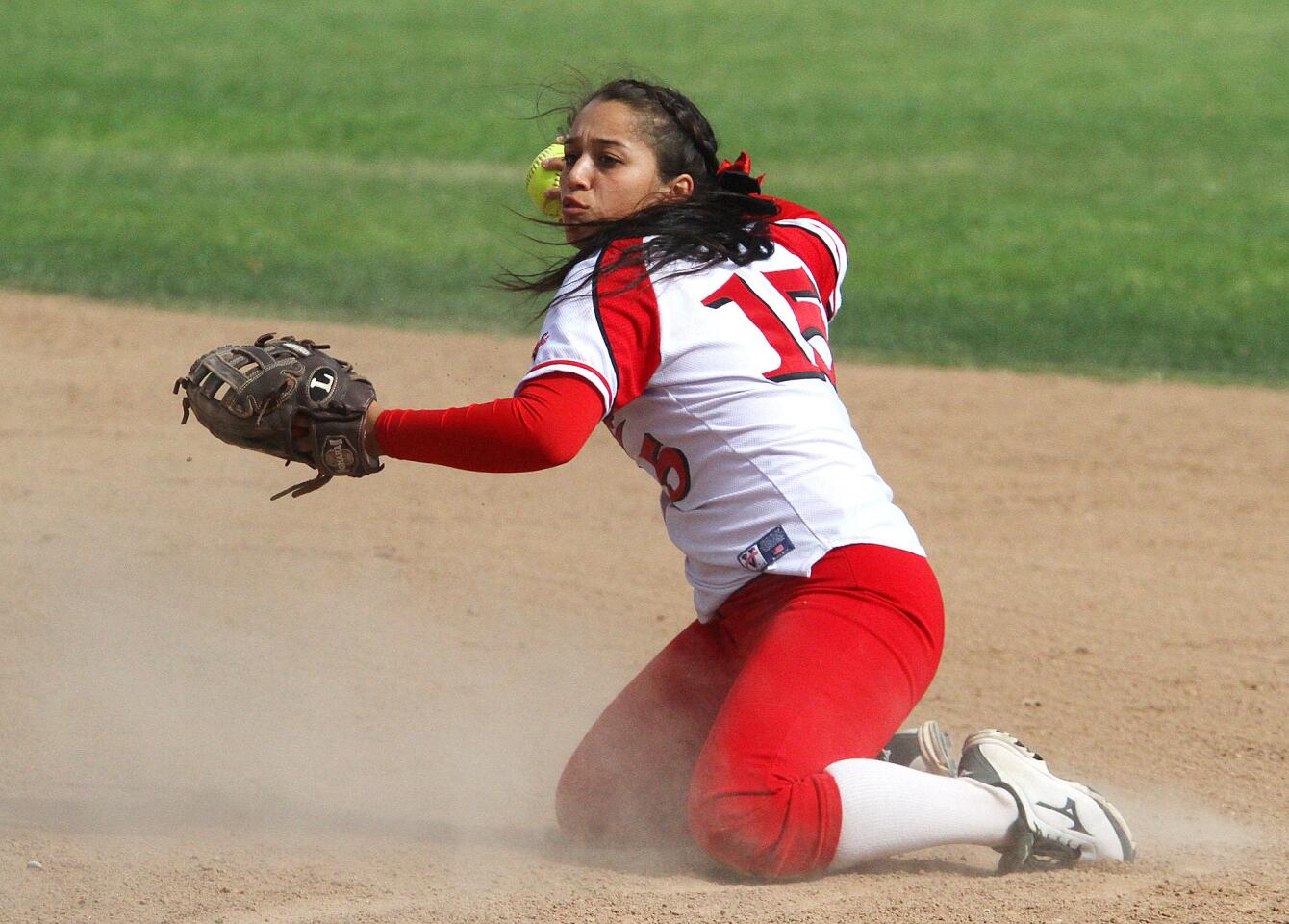 Burroughs' Aimee Rodriguez, at second base, dives and spins to make the throw for an out at first base against Glendale in a Pacific League softball game at Olive Park in Burbank on April 1, 2014. Burroughs won the game by mercy.