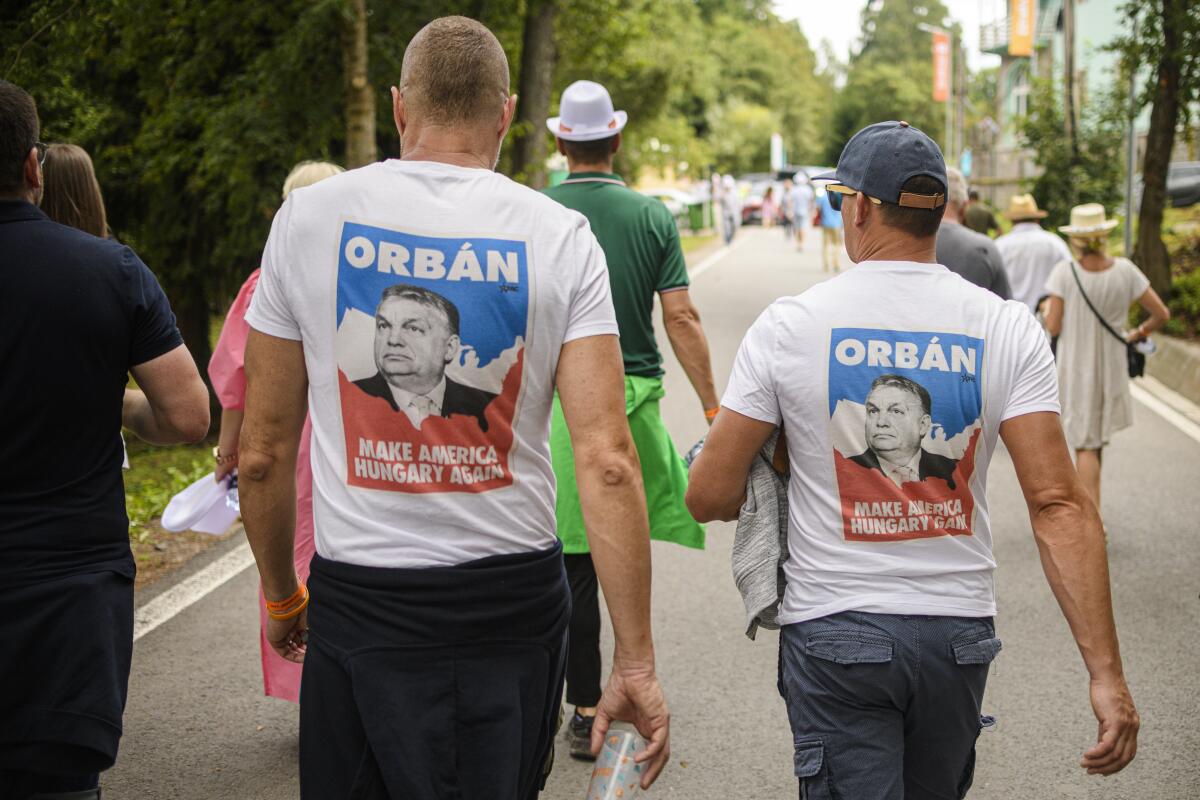 Two men wear T-shirts with a picture of Viktor Orban.