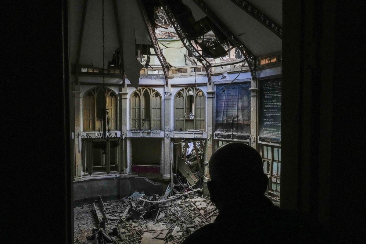 Rev. Barbaro Abel Marrero Castellanos, president of the Baptist Convention of Western Cuba, looks at the damage inside the Calvary Baptist Church after an explosion that devastated the Hotel Saratoga, which sits next door, in Old Havana, Cuba, Wednesday, May 11, 2022. The Baptists bought the property in 1889 and gradually established the church, a printing house, a school, a seminary and the headquarters that now serves about 70,000 Baptists in western Cuba. (AP Photo/Ramon Espinosa)