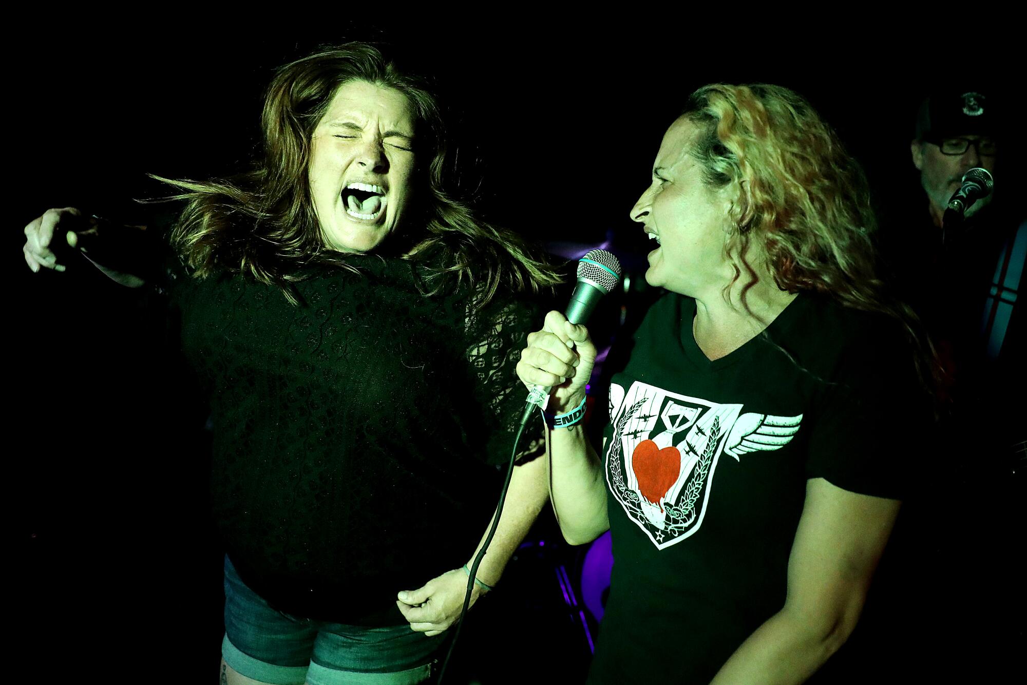 Two women sign onstage