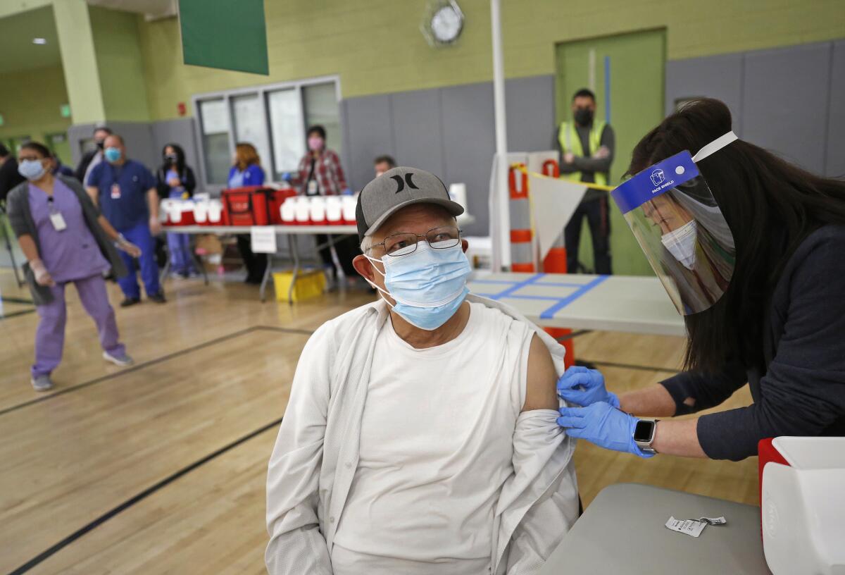 Teaching assistant Alfredo R. Fong, 70, gets his COVID-19 vaccination from Nurse Practitioner Mary Ann Topico.