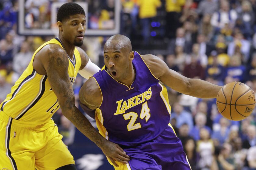 Lakers forward Kobe Bryant (24) drives to the basket against Pacers forward Paul George (13) during the first half.