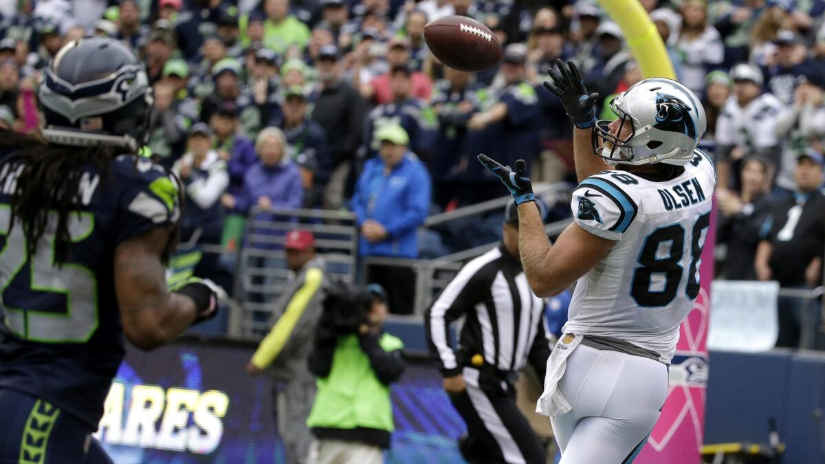 Panthers tight end Greg Olsen, right, catches a pass for a touchdown behind the defense of Seahawks cornerback Richard Sherman late in the fourth quarter Sunday.