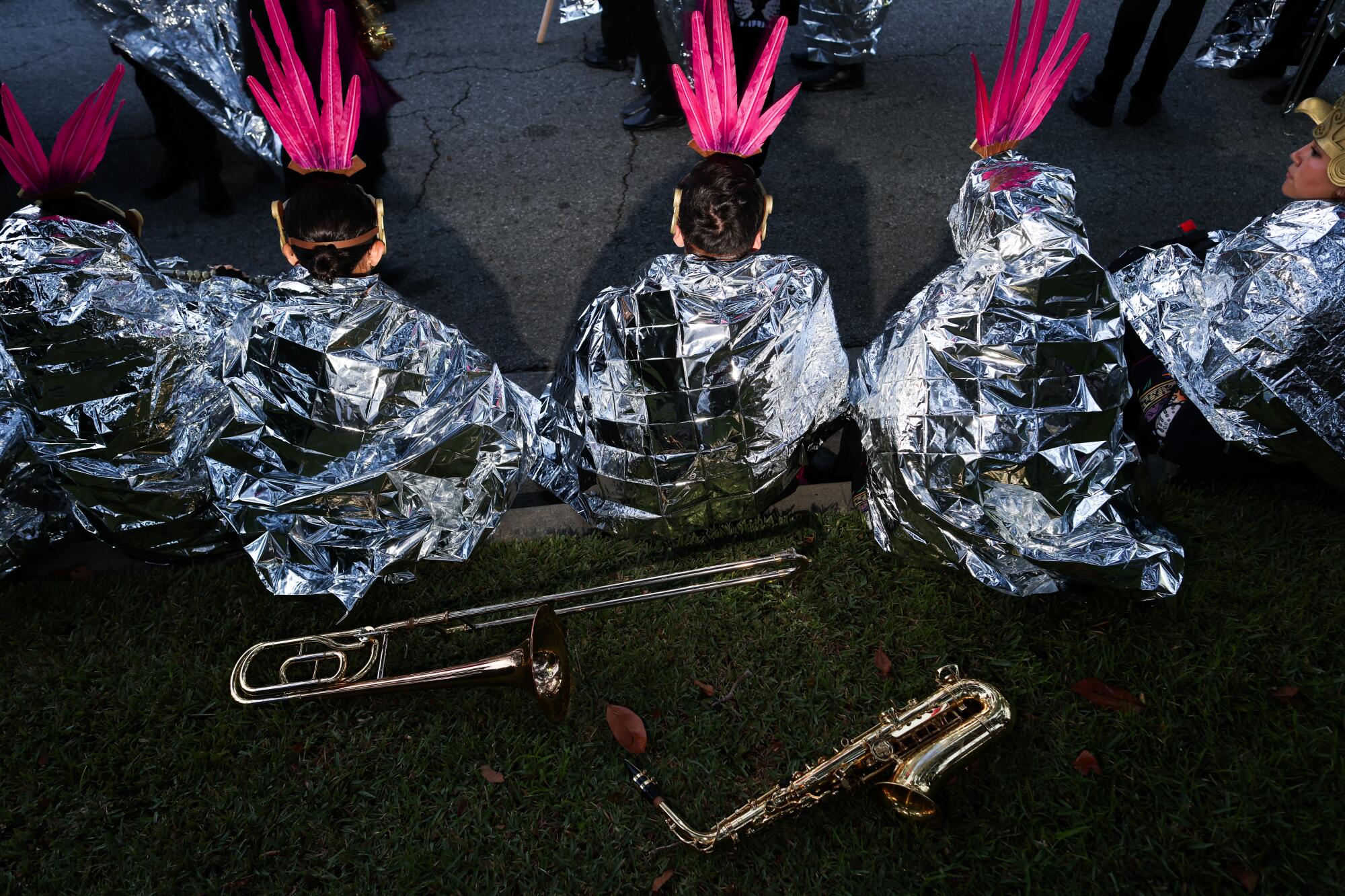 Band members with feathered headdresses are wrapped in Mylar blankets.
