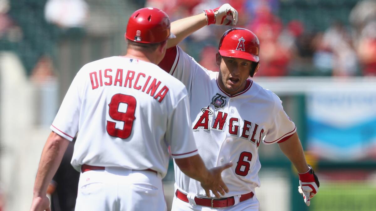 Angels third baseman David Freese, right, is congratulated by third base coach Gary DiSarcina after hitting a solo home run in the eighth inning of the team's 2-1 win over the Detroit Tigers on Sunday.