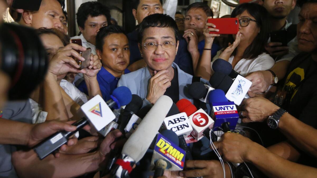 Maria Ressa listens to a reporter’s question after posting bail Thursday following her overnight arrest in Manila.