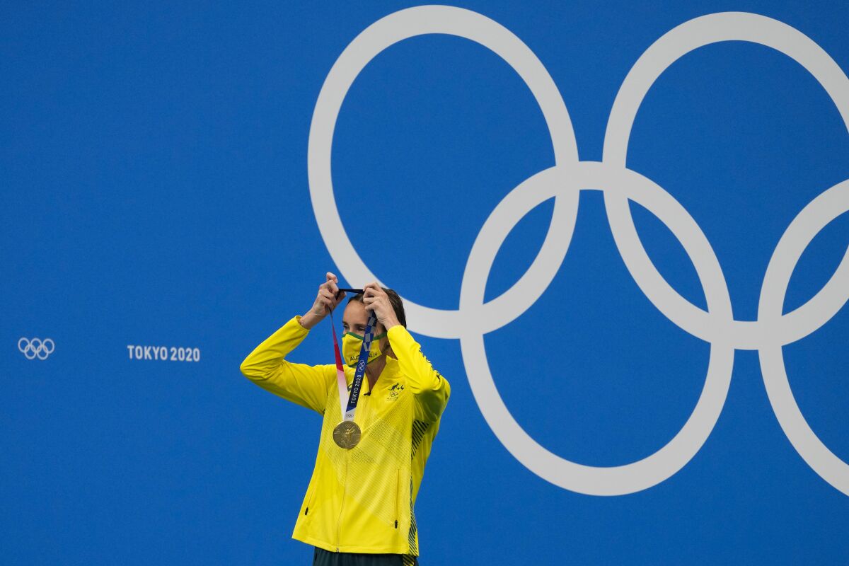 Emma Mckeon, of Australia, puts on her gold medal during a victory ceremony for the women's 50-meter freestyle final at the 2020 Summer Olympics, Sunday, Aug. 1, 2021, in Tokyo, Japan. (AP Photo/Jae C. Hong)