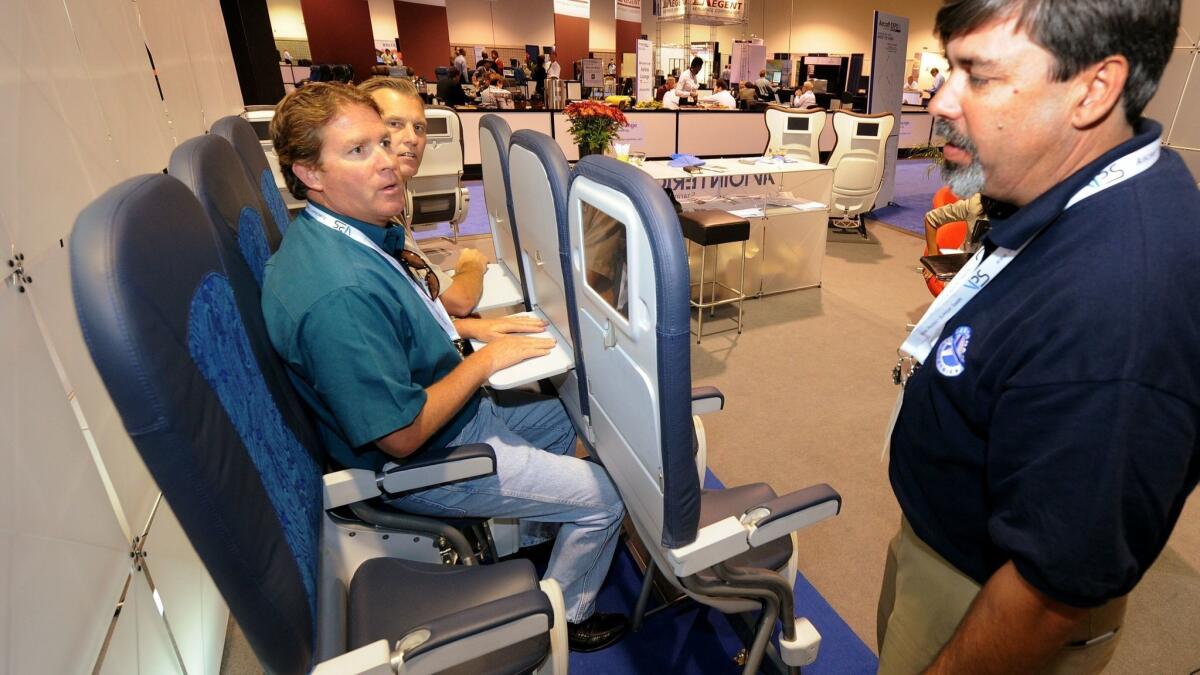 Airline industry insiders try out "standing seats" at the Aircraft Interiors Expo in Long Beach on Sept. 16, 2010.