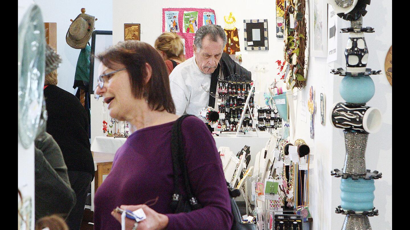 Several people browse on opening day at the Holiday Arts & Crafts Boutique at the Creative Arts Center in Burbank on Friday, December 4, 2015. The gallery features a lot of pottery, ornaments and jewelry all created by local artists.