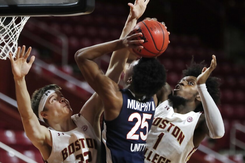 Boston College's Justin Vander Baan, left, and CJ Felder, right, block a shot by Virginia's Trey Murphy III, center, during the first half of an NCAA college basketball game, Saturday, Jan. 9, 2021, in Boston. (AP Photo/Michael Dwyer)