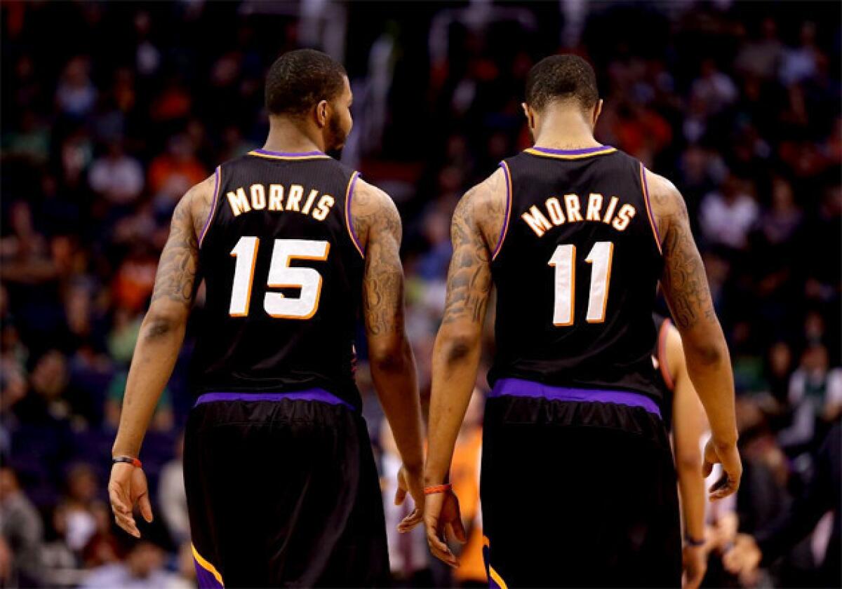 Phoenix Suns forwards Marcus (15) and Markieff Morris (11), who are twins, walk down the court together.