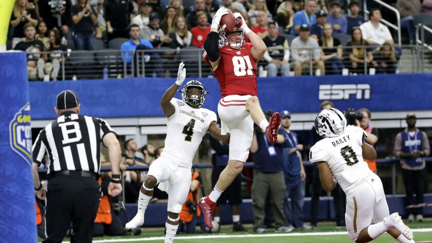 Wisconsin tight end Troy Fumagalli catches a touchdown pass against Western Michigan's Darius Phillips (4) and Caleb Bailey (8) during the fourth quarter of the Cotton Bowl on Monday.