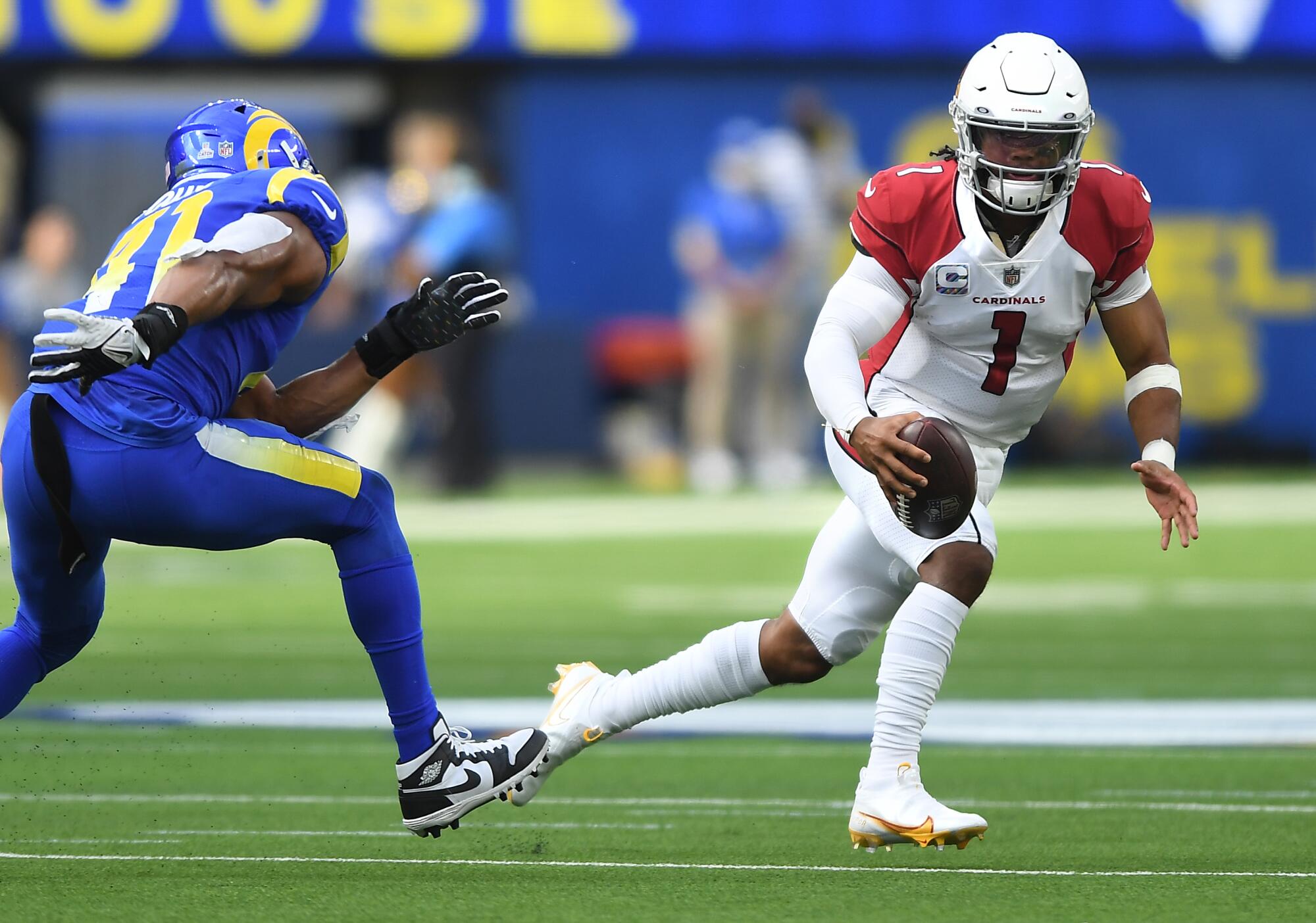 Arizona Cardinals quarterback Kyler Murray scrambles for a first down against Rams linebacker Kenny Young.