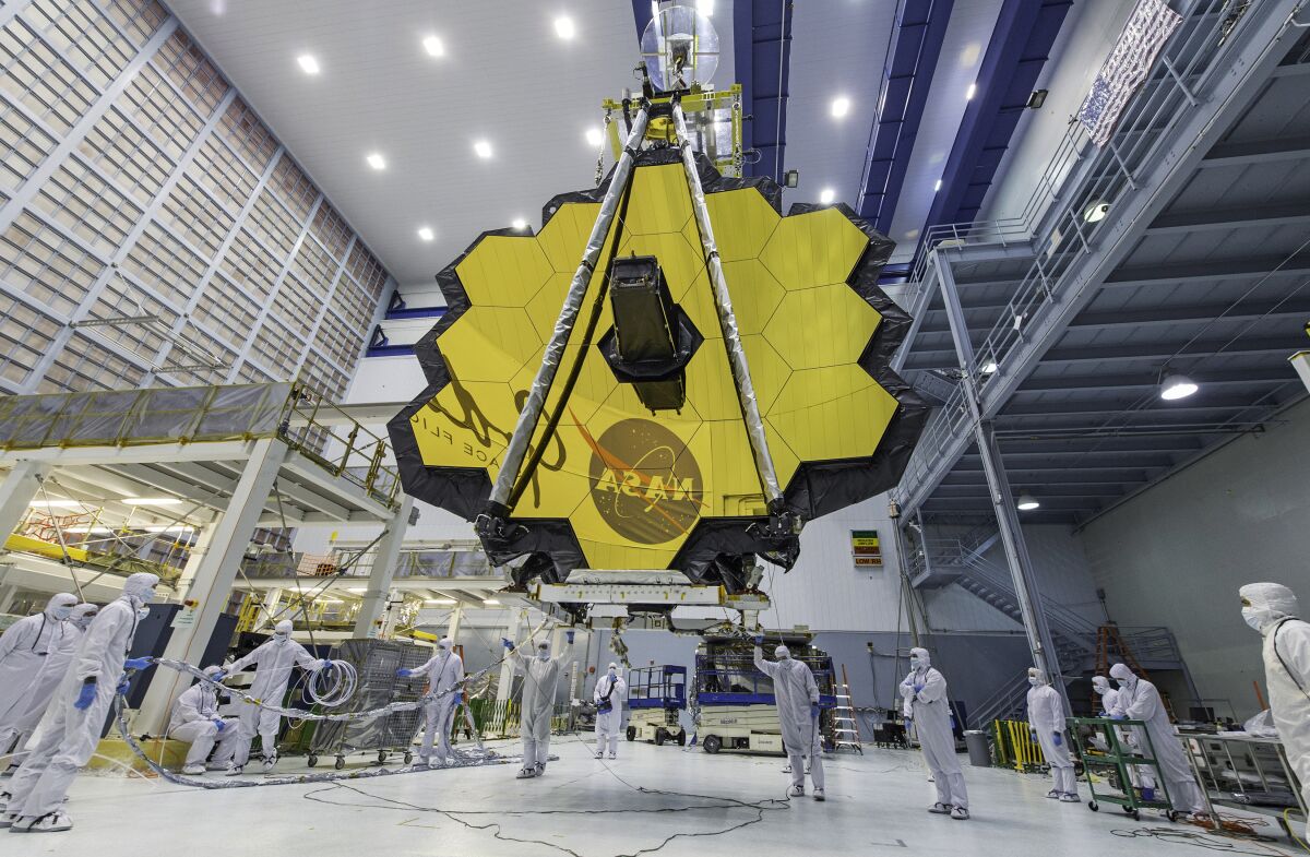 FILE - In this April 13, 2017 photo provided by NASA, technicians lift the mirror of the James Webb Space Telescope using a crane at the Goddard Space Flight Center in Greenbelt, Md. NASA announced Tuesday, Dec. 14, 2021, that next week’s launch of its new space telescope is delayed for at least two days because of a communication problem between the observatory and the rocket. Liftoff of the James Webb Space Telescope is now targeted for no earlier than Dec. 24. (Laura Betz/NASA via AP, File)