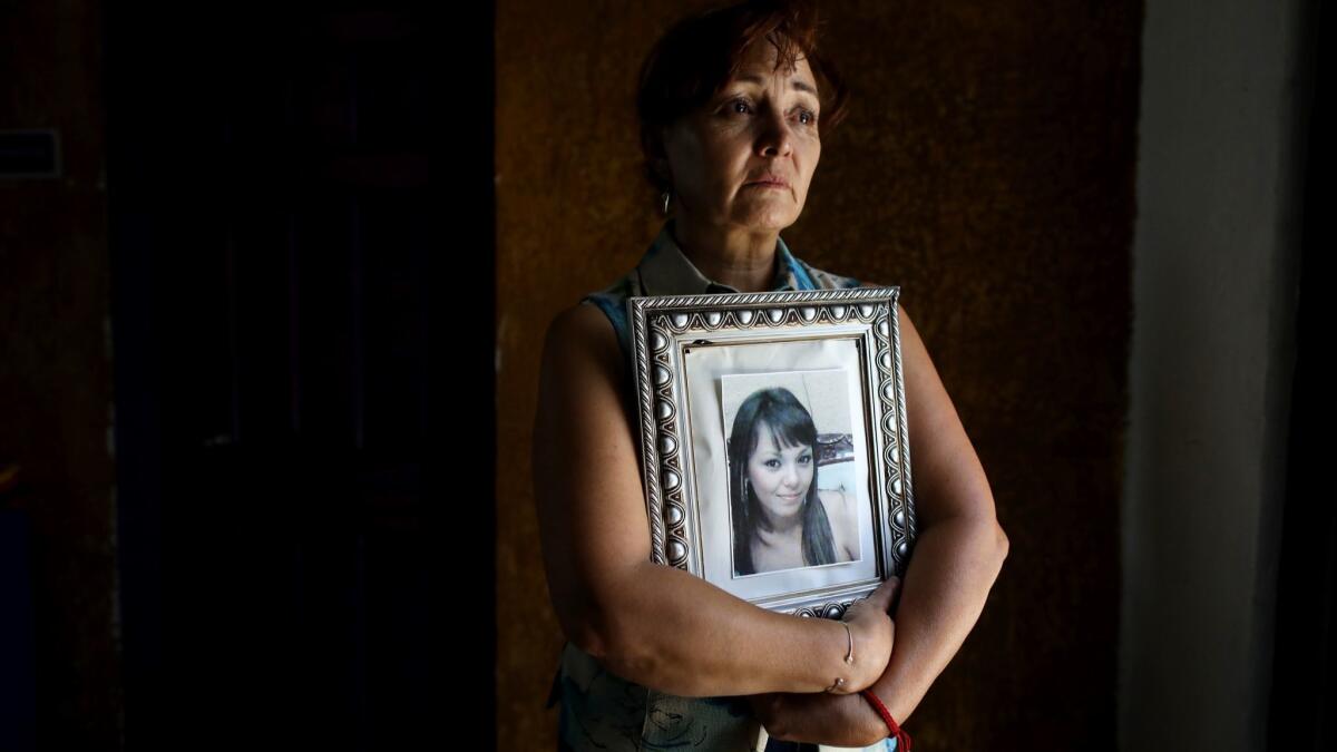 Lourdes Hernandez, 53, holds a portrait of her daughter Pamela Portillo, who went missing in 2010.