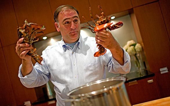Chef José Andrés faces off with two lobsters before they go into the pot for his lobster and potatoes dish in his home in Bethesda, Md.