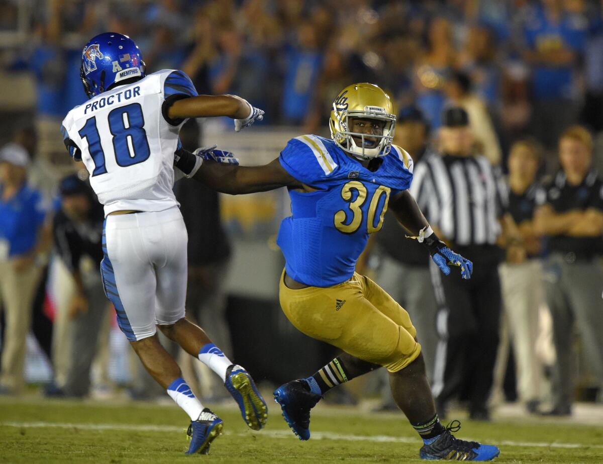 UCLA linebacker Myles Jack, right, keeps a hand on Memphis wide receiver Roderick Proctor on Sept. 6.