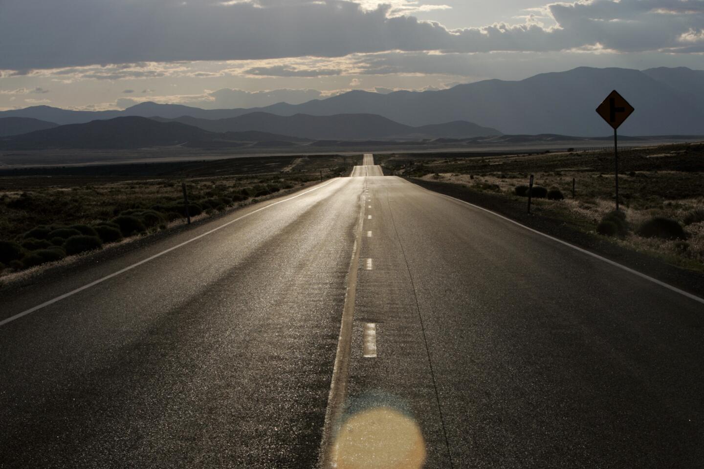 Snowcapped mountains form the backdrop to U.S. 50, dubbed America's "Loneliest Highway," in this scene east of Fernley, Nev.