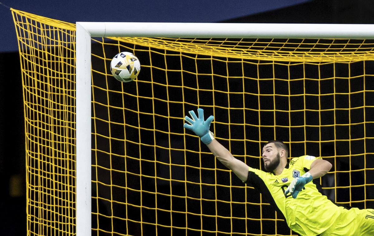 Vancouver Whitecaps goalkeeper Maxime Crepeau dives for the ball as a Portland Timbers shot goes wide of the goal during the second half of an MLS soccer match Friday, Sept. 10, 2021, in Vancouver, British Columbia. (Darryl Dyck/The Canadian Press via AP)