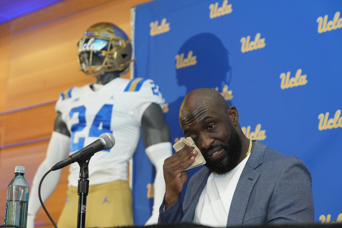 O ex-grande jogador da UCLA, DeShaun Foster, enxuga as lágrimas ao ser apresentado como o novo treinador de futebol da escola na terça-feira.