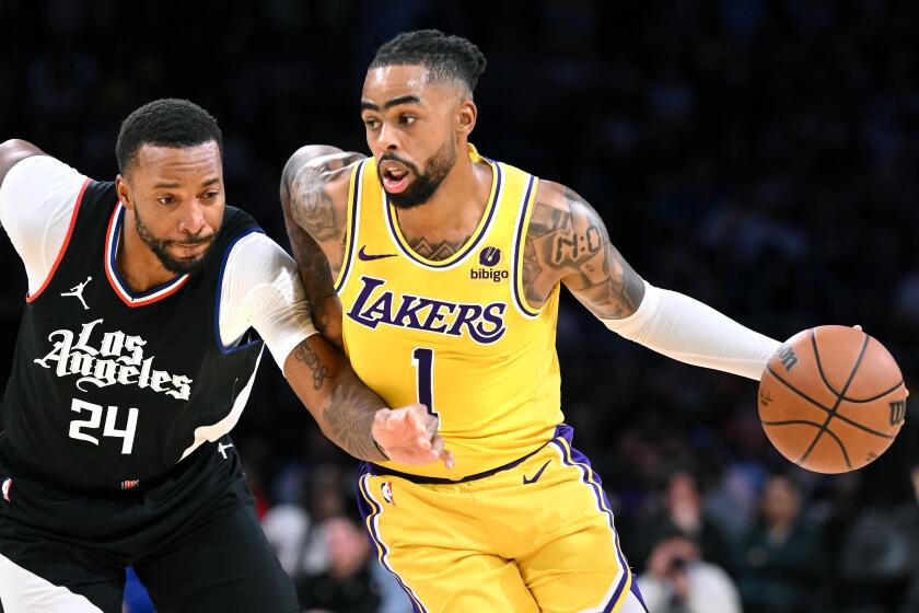 Los Angeles, California November 1, 2023- Lakers D'Angelo Russell drives past Clippers Norman Powell.