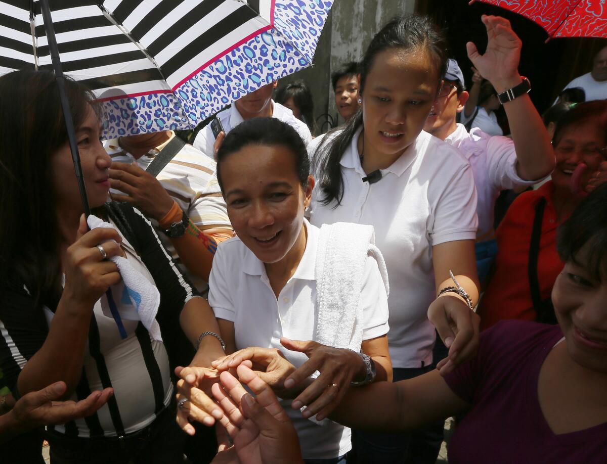 Presidential candidate Sen. Grace Poe is greeted by supporters after stopping briefly at a Roman Catholic church to pray in Cavite province on May 3, 2016.