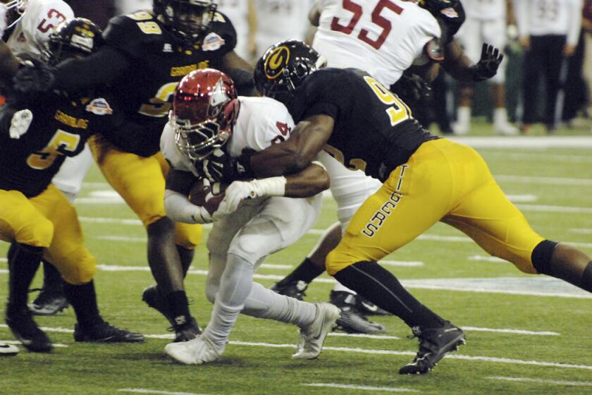 North Carolina Central running back Dorrel McClain is surrounded on the tackle by Grambling State defenders during the first half of the Celebration Bowl on Saturday.