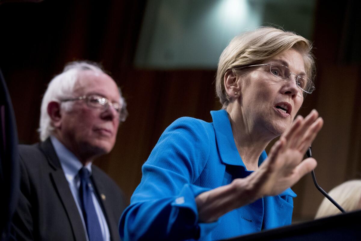 Sen. Elizabeth Warren (D-Mass.) speaks as Sen. Bernie Sanders (I-Vt.) listens during a 2017 news conference on "Medicare for all" legislation.