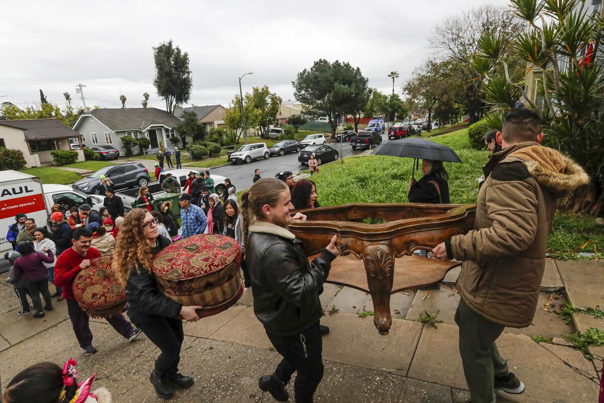 Volunteers help move Martha Escudero into of a vacant house she and other protesters occupied on Saturday morning.