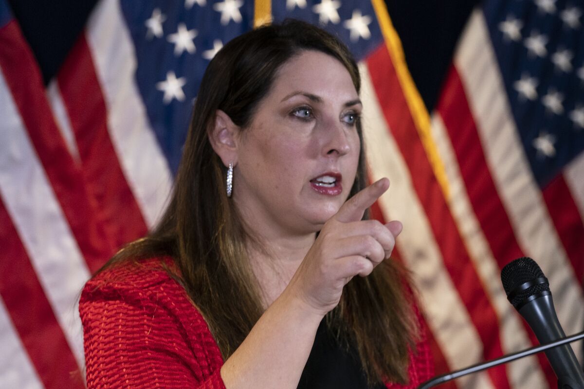 Republican National Committee Chairwoman Ronna McDaniel speaks in front of American flags.