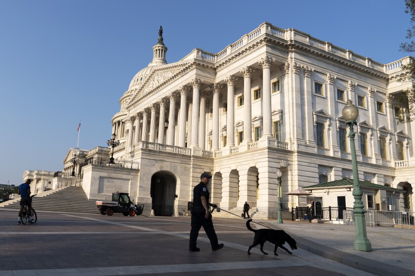 The U.S. Capitol is seen in Washington on July 27, 2021, as U.S. Capitol police watch the perimeter. 